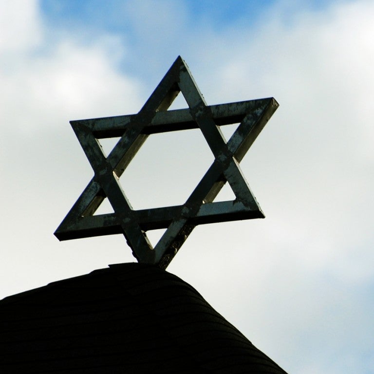 Star of David atop a building against a cloud sky