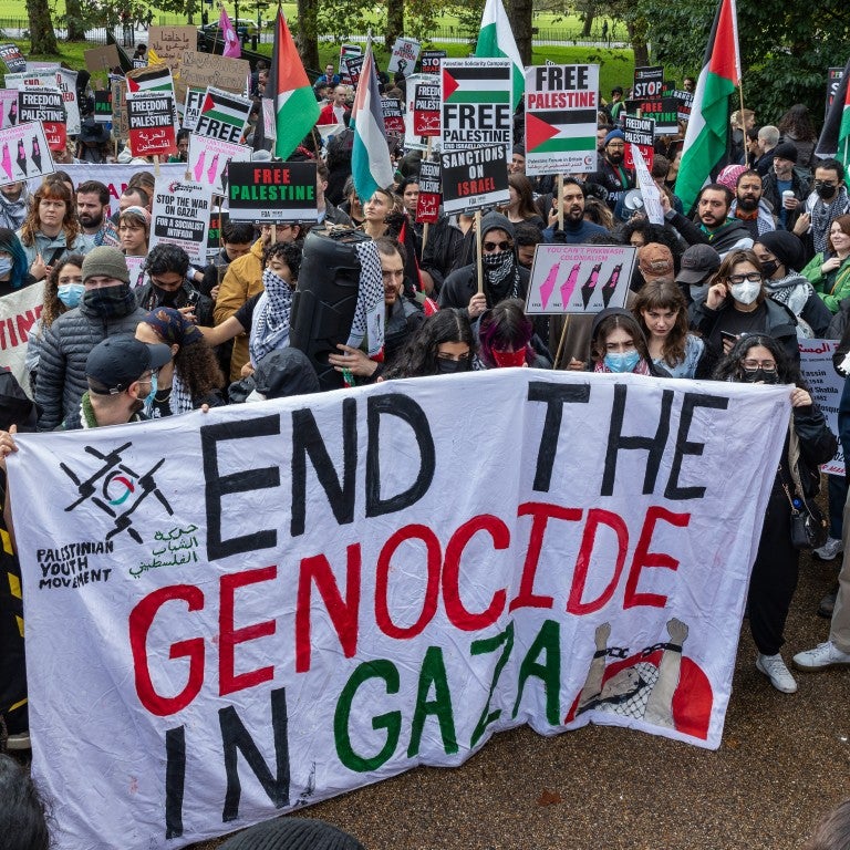 Protest with the sign that says "End the Genocide in Gaza"