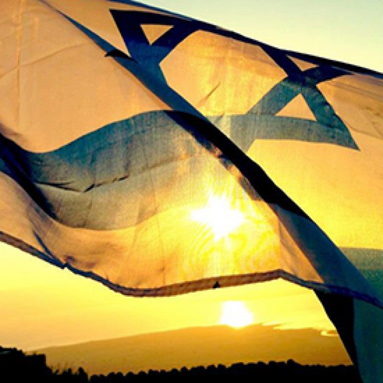 Photo of the Israel flag waving at sunset