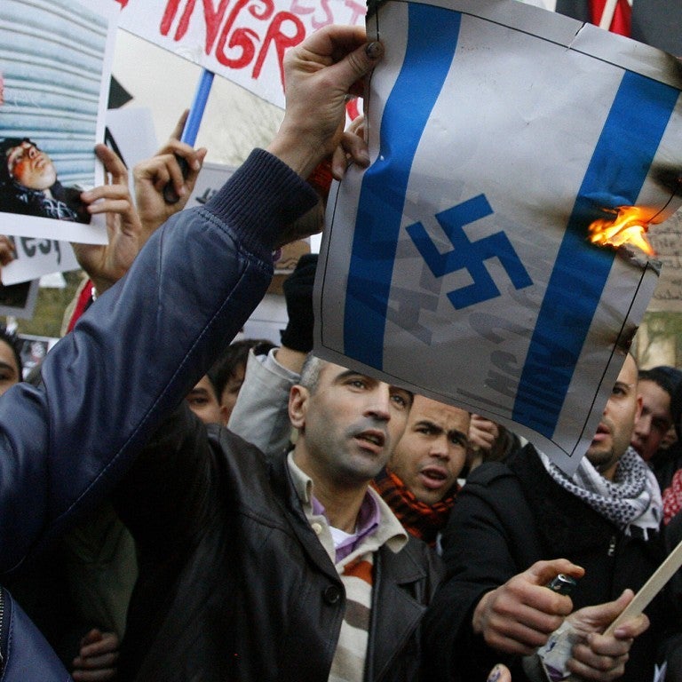 Photo of a burning image of the Israeli flag with a swastika