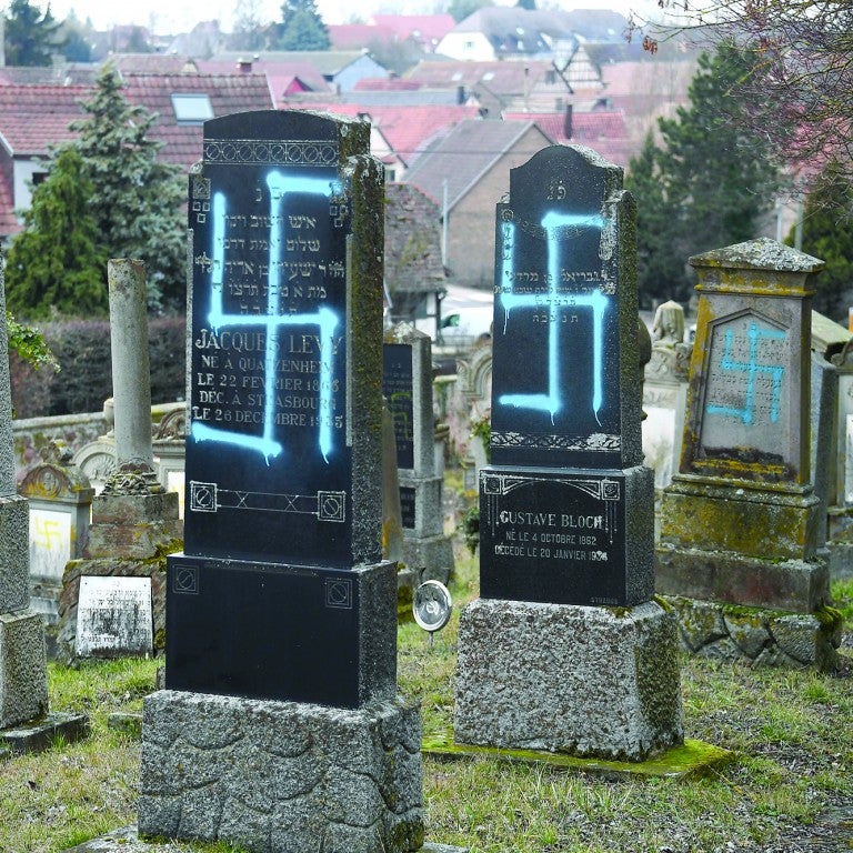 Photo of a cemetery in France with blue graffiti