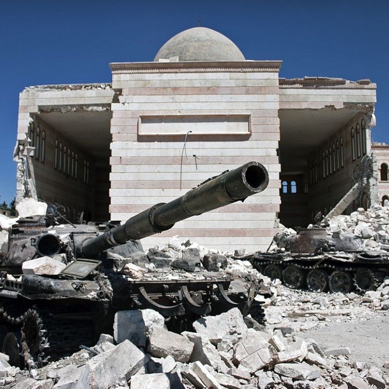 Two destroyed tanks in front of a mosque in Azaz, Syria
