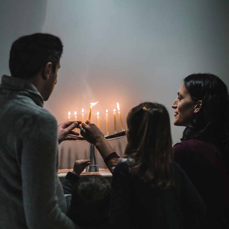 Jewish family lighting candles