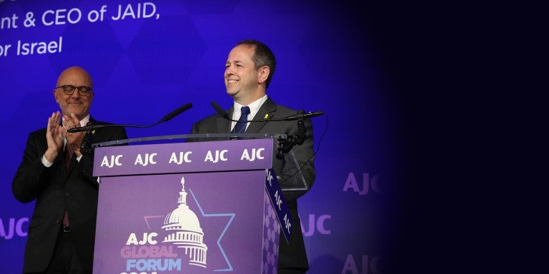 Image of AJC CEO Ted Deutch and Dan Elbaum at the podium of AJC's 2024 Global Forum