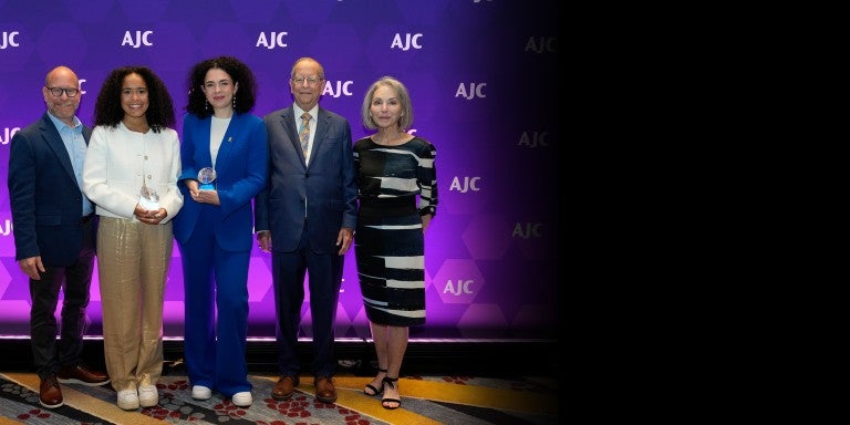 Image of Bill, Susan, and Josh Greene presenting the AJC Sharon Greene Award for Campus Advocacy to Hannah Veiler and Noa Fay at AJC's 2024 Global Forum