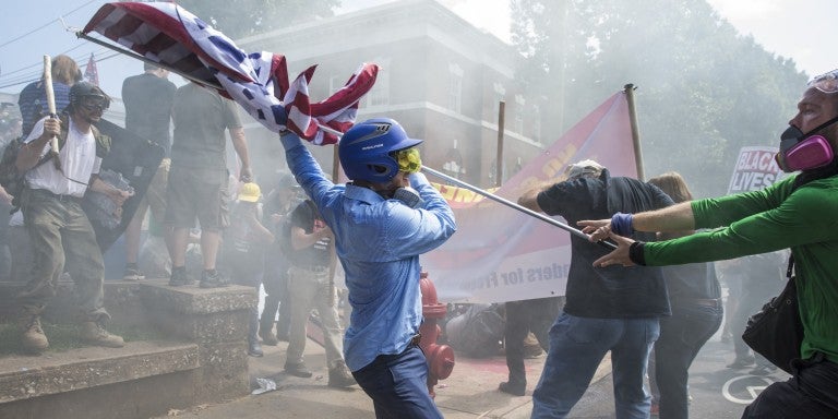 A White Supremacist tries to strike a counter protestor with a White Nationalist flag during clashes at Emancipation Park where the White Nationalists are protesting the removal of the Robert E. Lee monument in Charlottesville, Va., USA on August 12, 2017. 