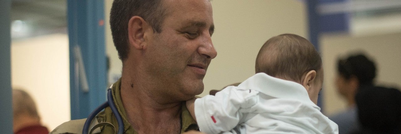 Photo of Israeli doctor holding a Syrian baby