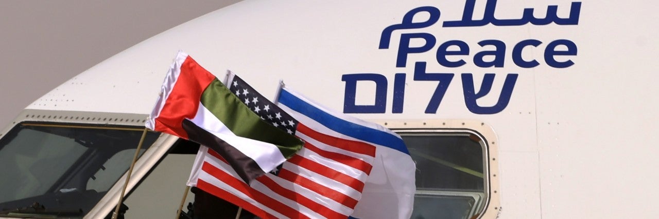 Flags of the US, Israel, UAE hang out an airplane window