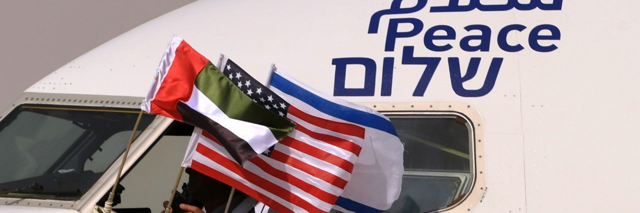 The Emirati, Israeli and US flags are picture attached to an air-plane of Israel's El Al, adorned with the word "peace" in Arabic, English and Hebrew