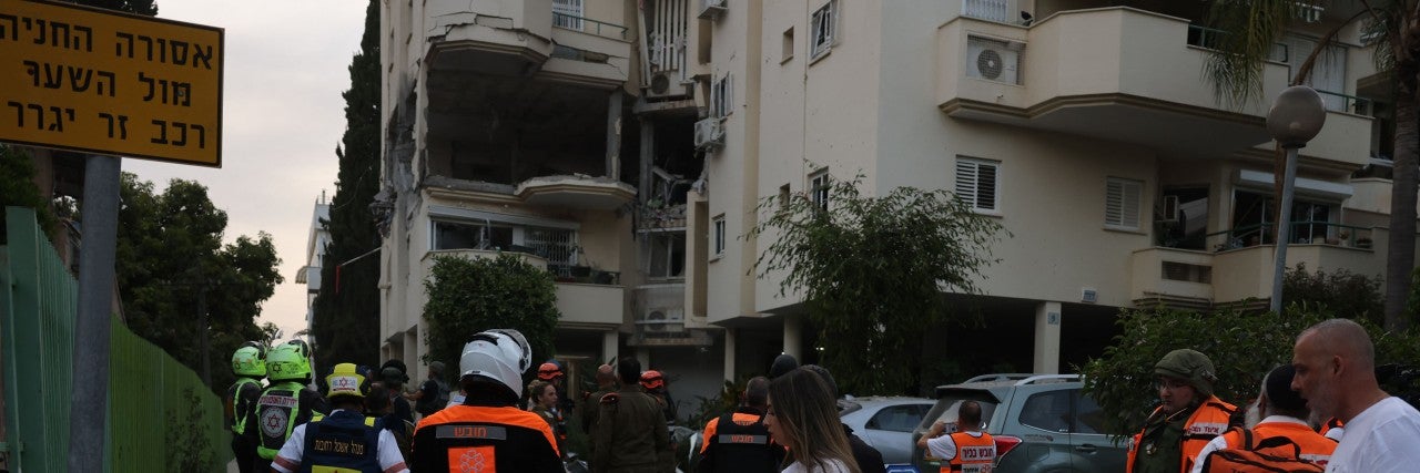 Israeli forces and rescuers secure the area near a building hit by a rocket fired from the Gaza strip, in Rehovot near Tel Aviv, on May 11, 2023.