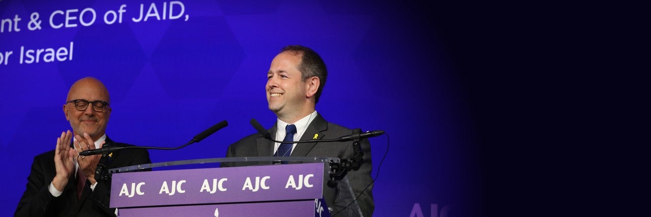 Image of AJC CEO Ted Deutch and Dan Elbaum at the podium of AJC's 2024 Global Forum