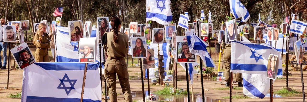  Israeli soldiers walk among portraits of people taken captive or killed by Hamas militants during the Supernova music festival on October 7, during a visit at the site where the deadly incident took place near Kibbutz Reim in southern Israel, on January 11, 2024, amid continuing battles between Israel and Hamas in Gaza. 