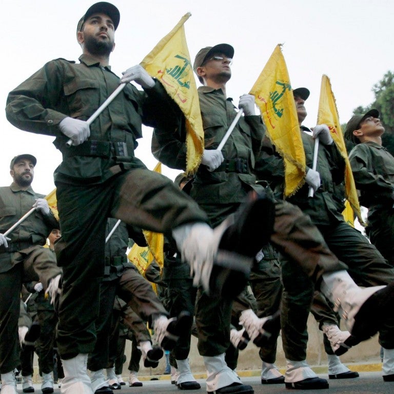 Hezbollah militants marching with flags
