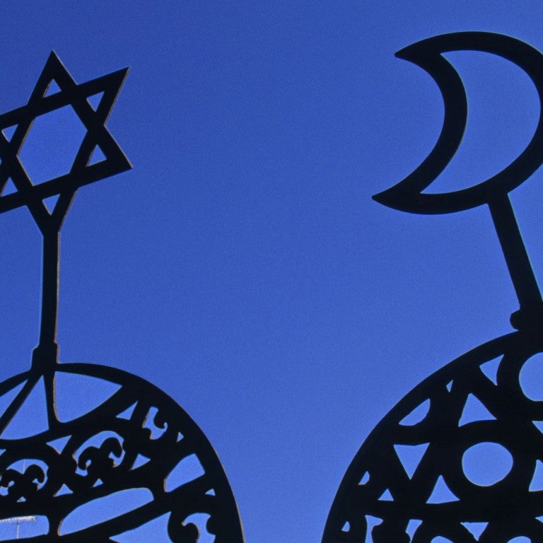 Christian, Jewish, and Muslim symbols displayed on a blue backdrop.