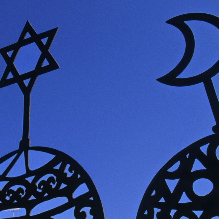 Christian, Jewish, and Muslim symbols displayed on a blue backdrop.