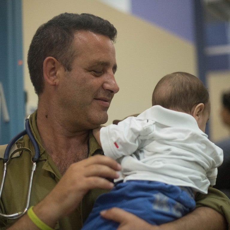 Photo of Israeli doctor holding a Syrian baby