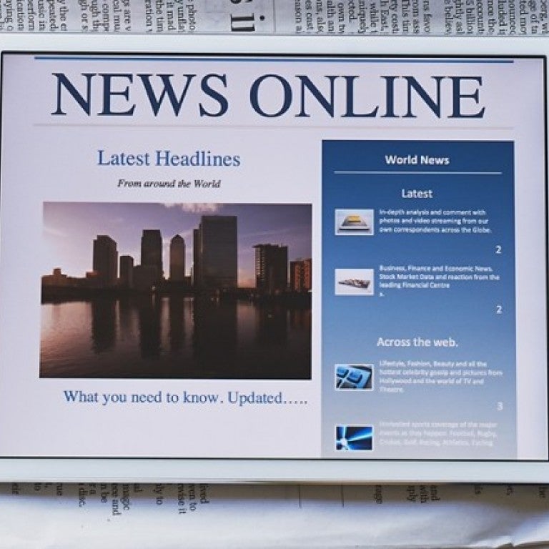 iPad saying "News Online" with a newspaper behind