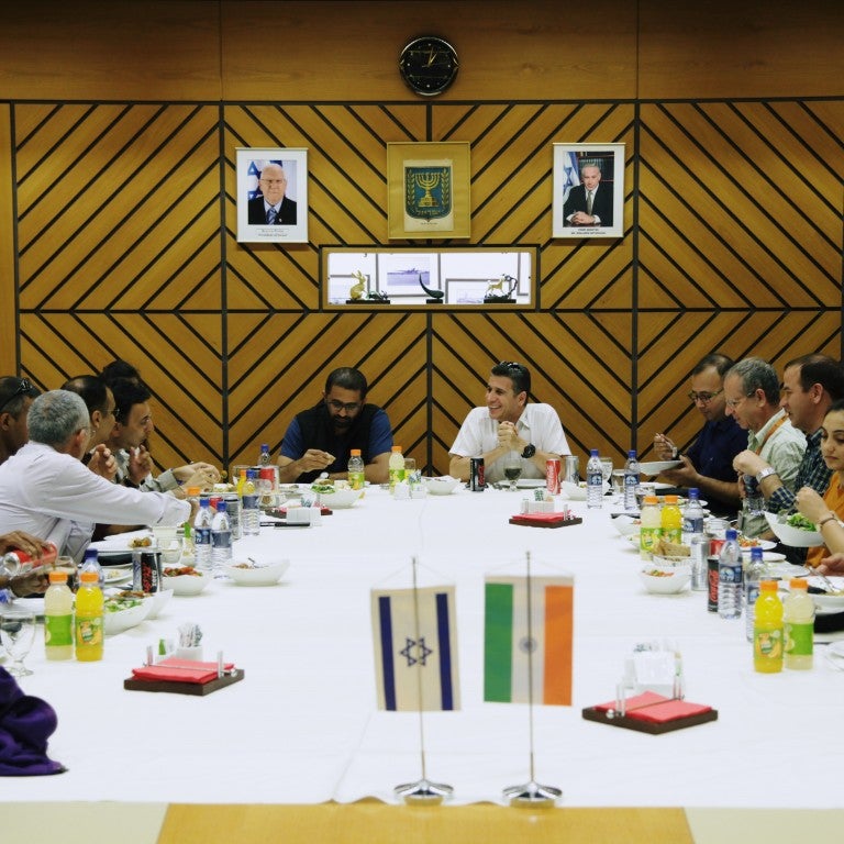 Delegation sitting in Israel. Indian and Israeli flag on the table.