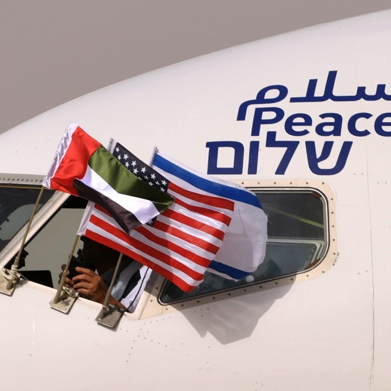 The Emirati, Israeli and US flags are picture attached to an air-plane of Israel's El Al, adorned with the word "peace" in Arabic, English and Hebrew