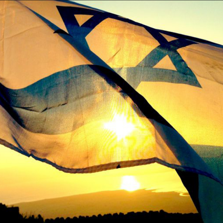 Israeli flag waving in the wind with sunrise in background
