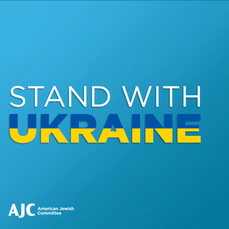 Says Stand with Ukraine with Ukraine letters in colors of Ukraine flag blue on top and yellow on botto.