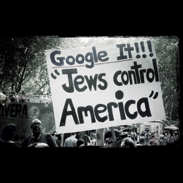 Black and White photo of a sign saying "Google it!! Jews control America"