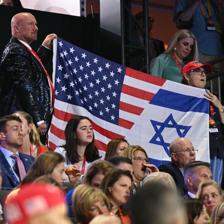 Attendees hold a flag made from the US and Israel flag during the third day of the 2024 Republican National Convention at the Fiserv Forum in Milwaukee, Wisconsin, on July 17, 2024. Days after he survived an assassination attempt Donald Trump won formal nomination as the Republican presidential candidate and picked Ohio US Senator J.D. Vance for running mate. 